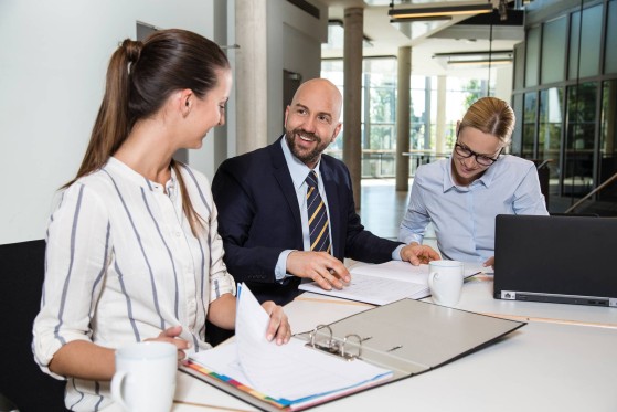 Drei-Personen-beraten-sich-an-einem-Tisch