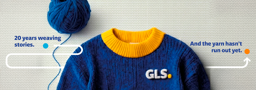 Blue knitted sweater with a yellow collar and GLS logo, accompanied by a ball of yarn and a corporate message celebrating 20 years of storytelling and brand heritage