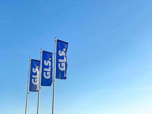 Drapeaux bleus GLS flottant au vent sous un ciel bleu clair.