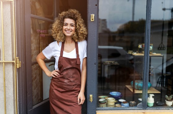female shop owner smiling standing at the door