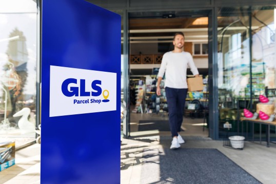 Woman collecting a parcel at a GLS parcel Shop