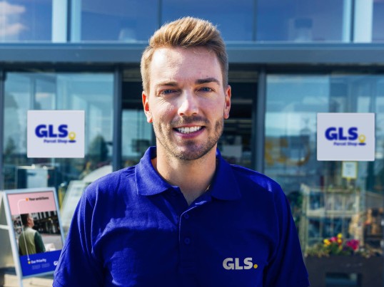 Un livreur de GLS devant un Parcel Shop de GLS