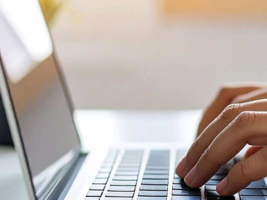 Hands typing on a laptop 